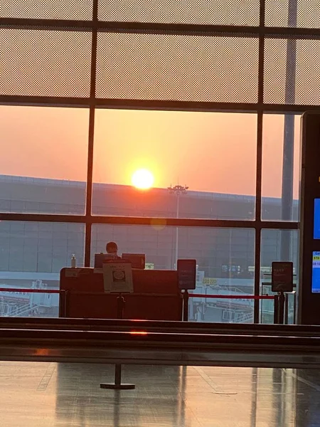 airport terminal with airplane and window at sunset