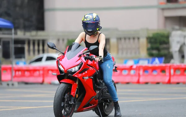 young woman riding motorcycle on the street