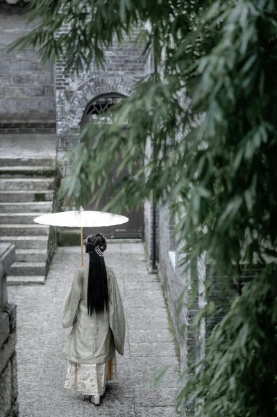 young woman in black dress with umbrella