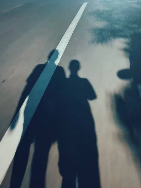 silhouette of a man in a black suit and a white shirt on the background of the road