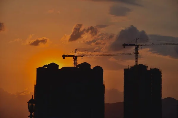 silhouette of a building under construction against the sky