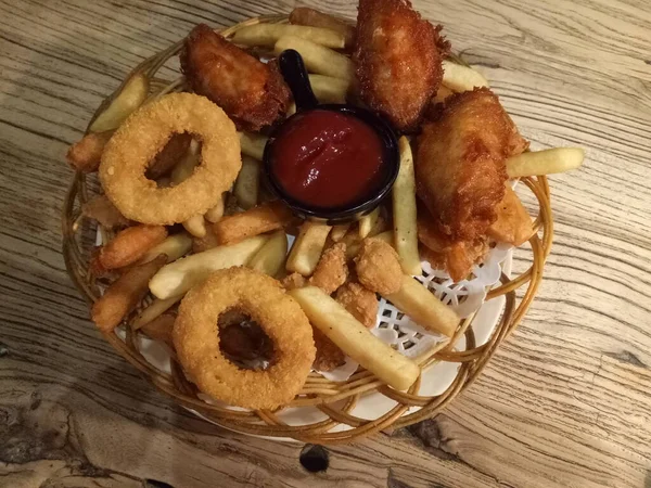 fried squid rings with sauce and ketchup