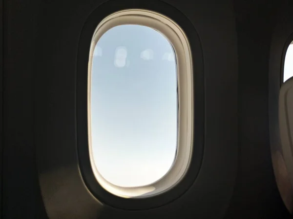 airplane window with white clouds