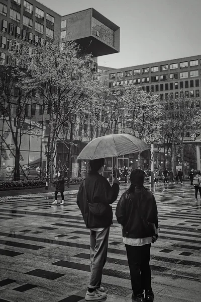 black and white photo of a couple in love walking in the city