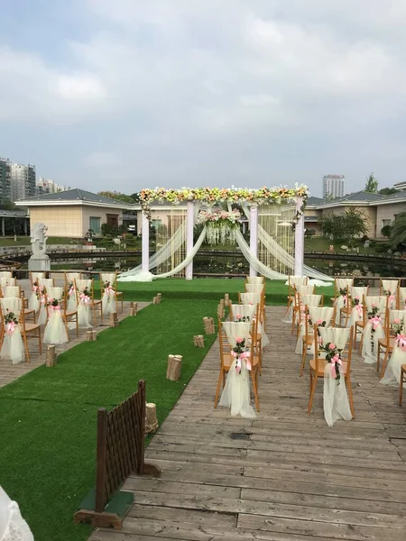 wedding arch with white flowers and chairs