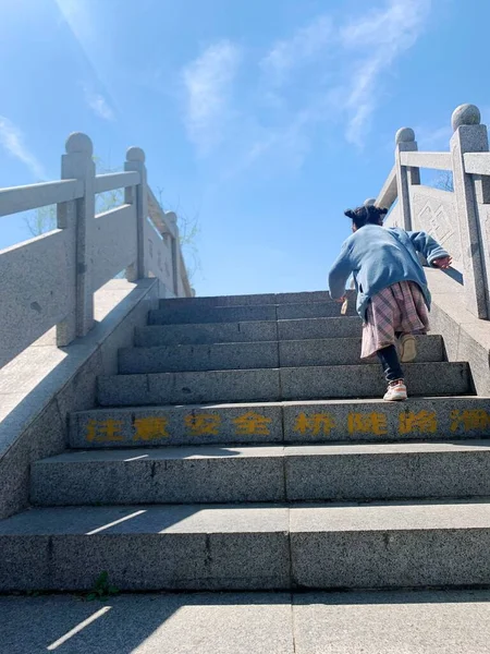 young woman with backpack walking on stairs