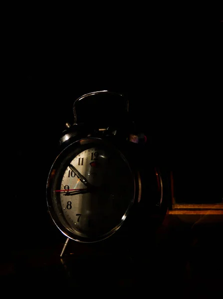 vintage alarm clock on black background