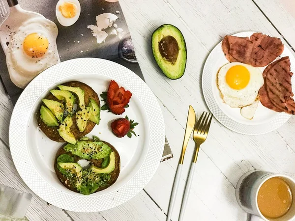 breakfast with egg, avocado, eggs, and toast on a wooden table. top view.