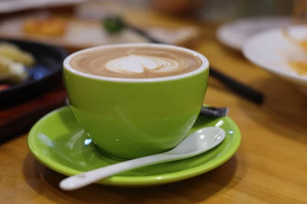 hot coffee with green tea cup on wooden table