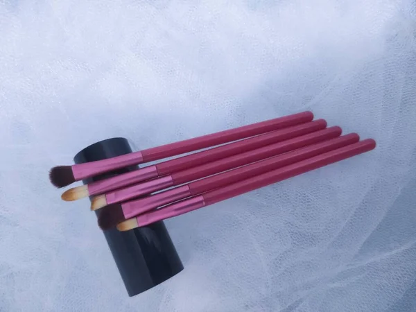 set of makeup brushes on a black background.