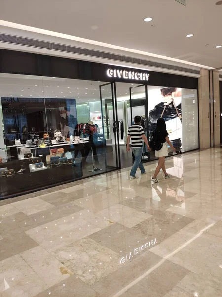 shopping mall, people and fashion concept-young man with mannequins in showroom
