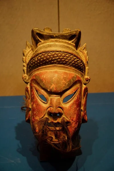 a closeup shot of a wooden sculpture with a mask