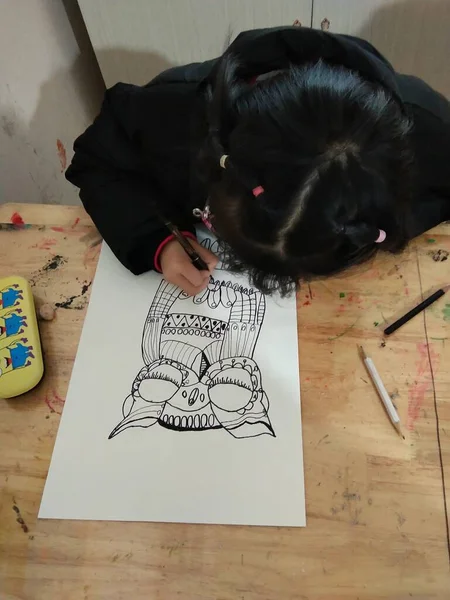 girl drawing a book on a carpet