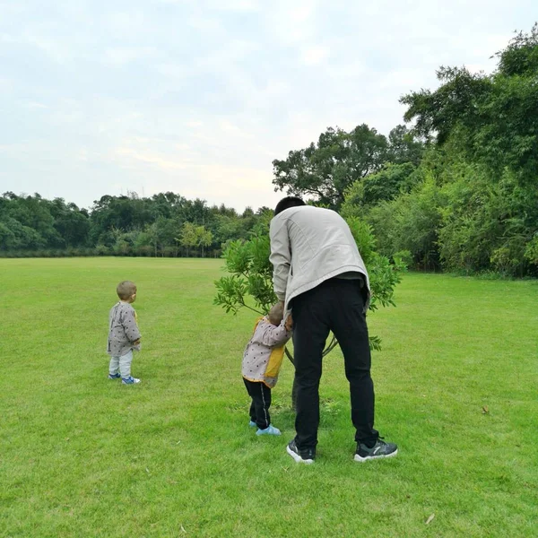 father and son playing golf with his grandson