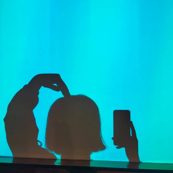 silhouette of a woman with a smartphone on a blue background