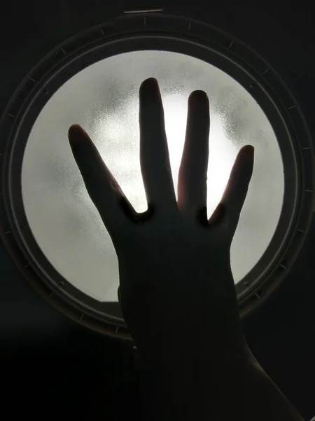 hand with black glove on the background of the window