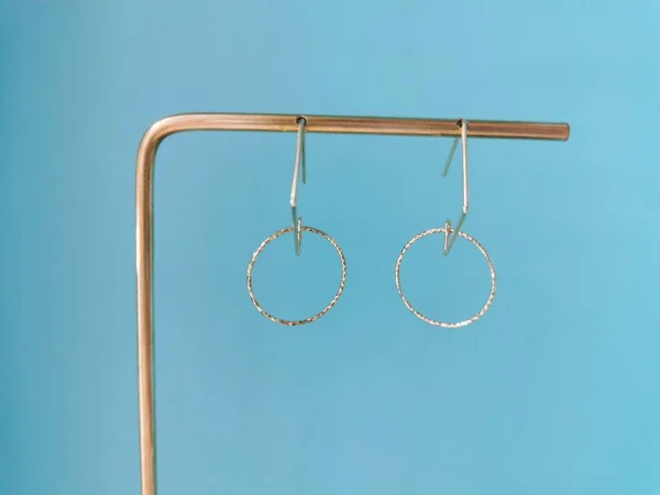 set of earrings hanging on a blue background