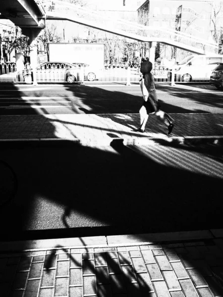 black and white photo of a man in the city