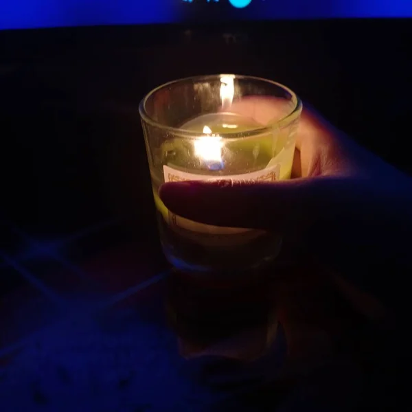 candle in the hands of a woman in a dark room with a burning candles
