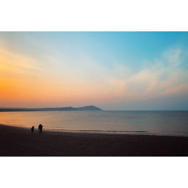 silhouette of a man and woman on the beach