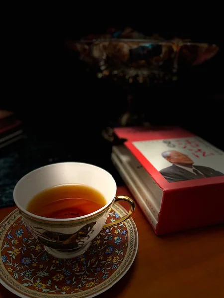 cup of tea and a book on a wooden background