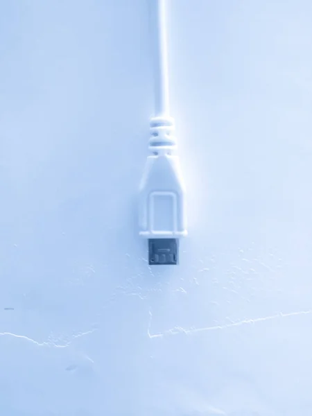 white usb cable on a blue background
