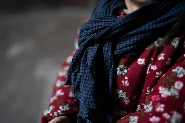 close up of a woman in a scarf and a bag of red and white knitted fabric