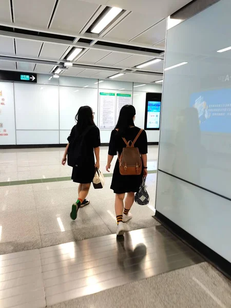 woman in airport with luggage walking in subway station