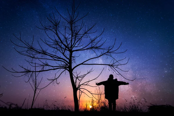 silhouette of a man with a moon in the sky