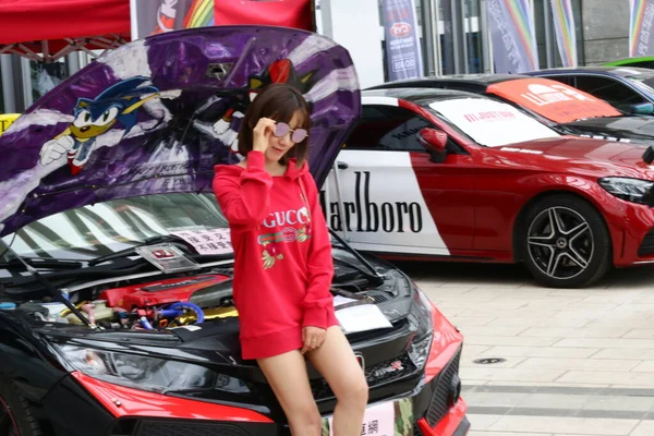 young woman in red car with a lot of cars