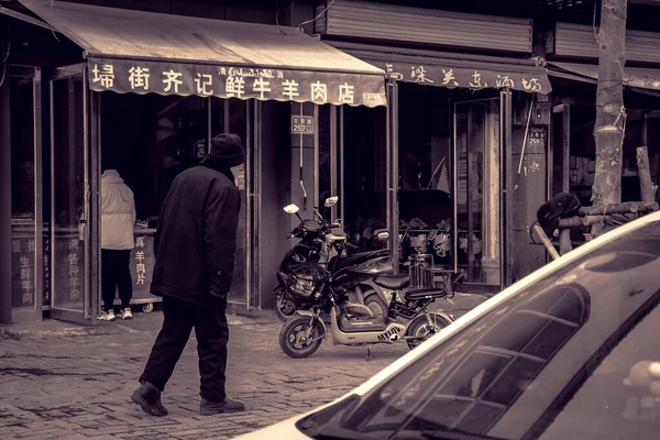 old man in a suit with a motorcycle