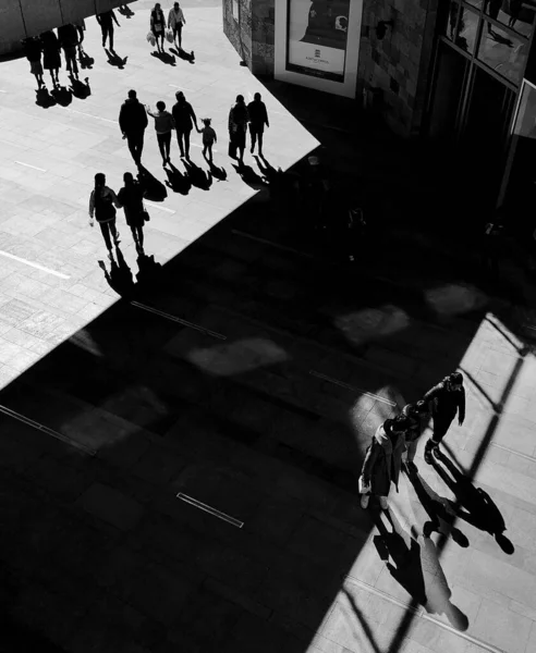 black and white photo of a crowd of people walking in the city