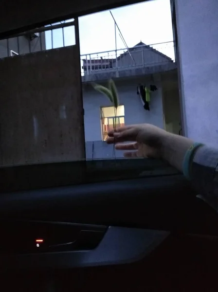 a man in a black suit with a laptop in the background of the window