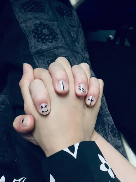 close up of a woman\'s hand with a tattoo on a black background