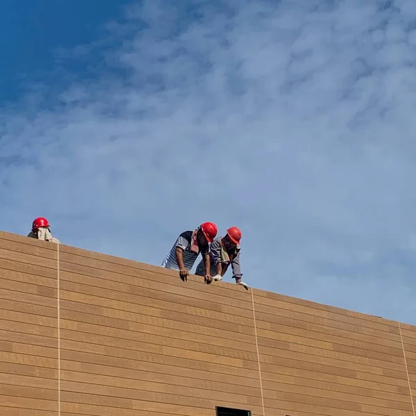 construction workers working on a roof of a house