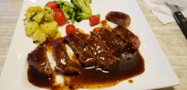 grilled beef steak with sauce and vegetables