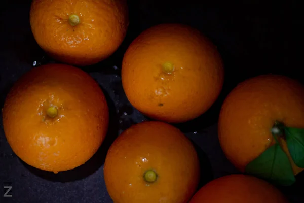 fresh orange fruits on a black background