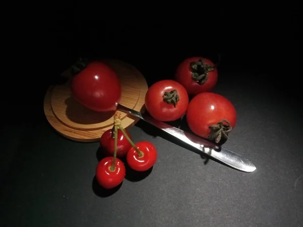 red and black tomatoes on a dark background