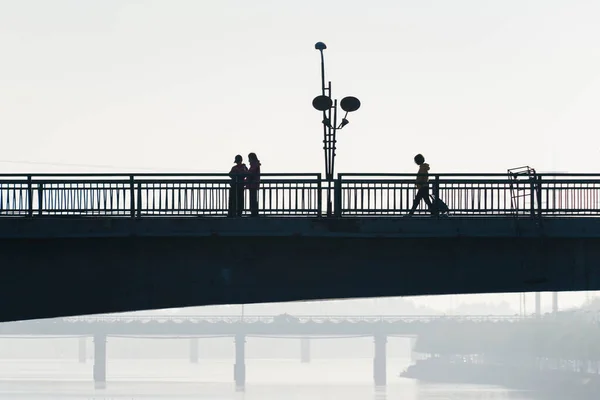 silhouette of a man and woman on the bridge