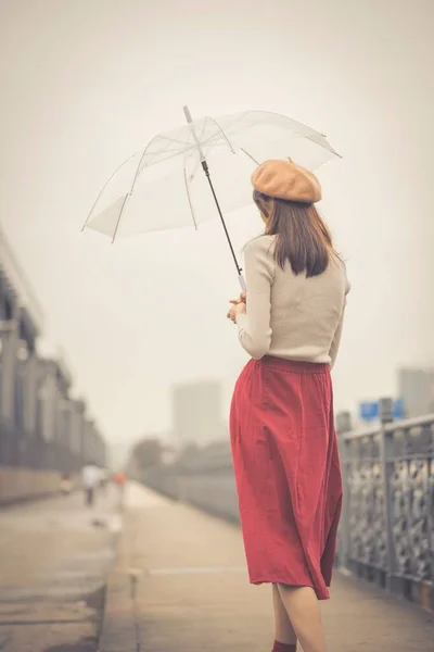young woman with umbrella on the street