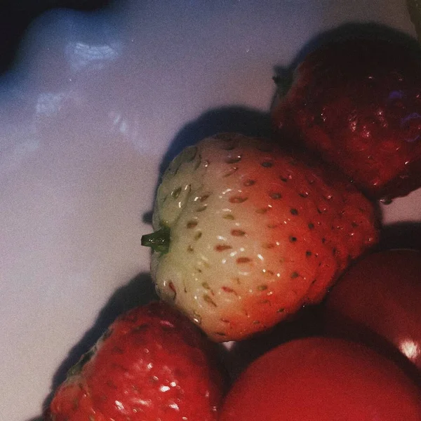 close up of a red and white strawberry