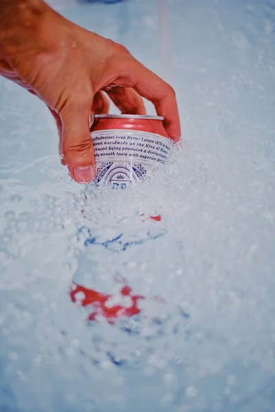 man in a blue jacket is holding a red rubber seal on the ice.
