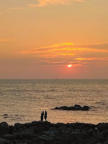 silhouette of a man and woman on the beach