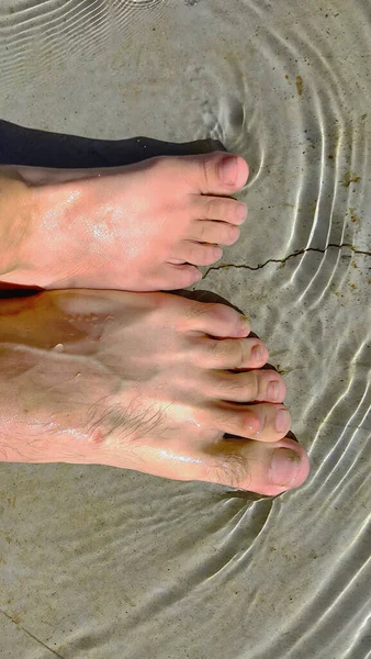 feet of a woman\'s legs on the beach