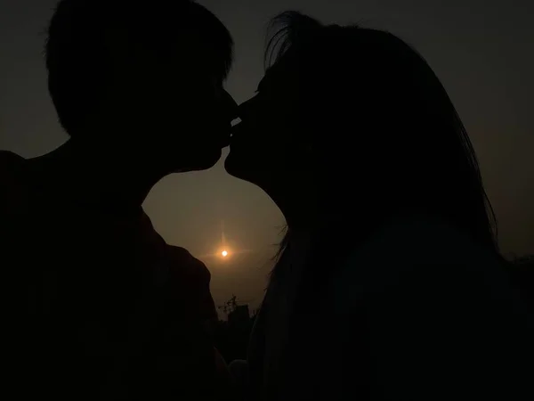 silhouette of couple kissing on the beach