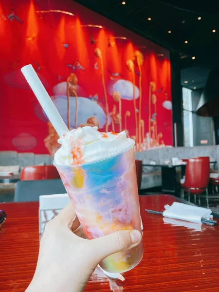 a glass of cocktail with ice cream and a red drink