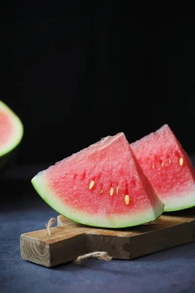 sliced ripe watermelon on a black background