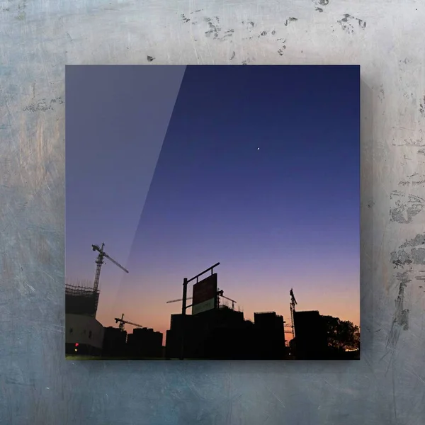 silhouette of a building with a crane and a skyscraper