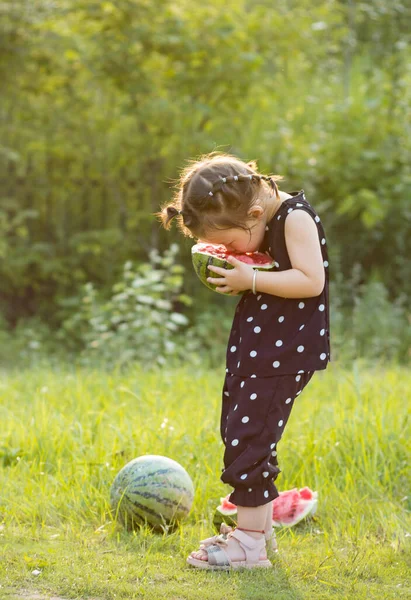 little girl playing with a ball in the park