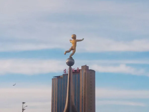 a man in a suit is walking on the beach